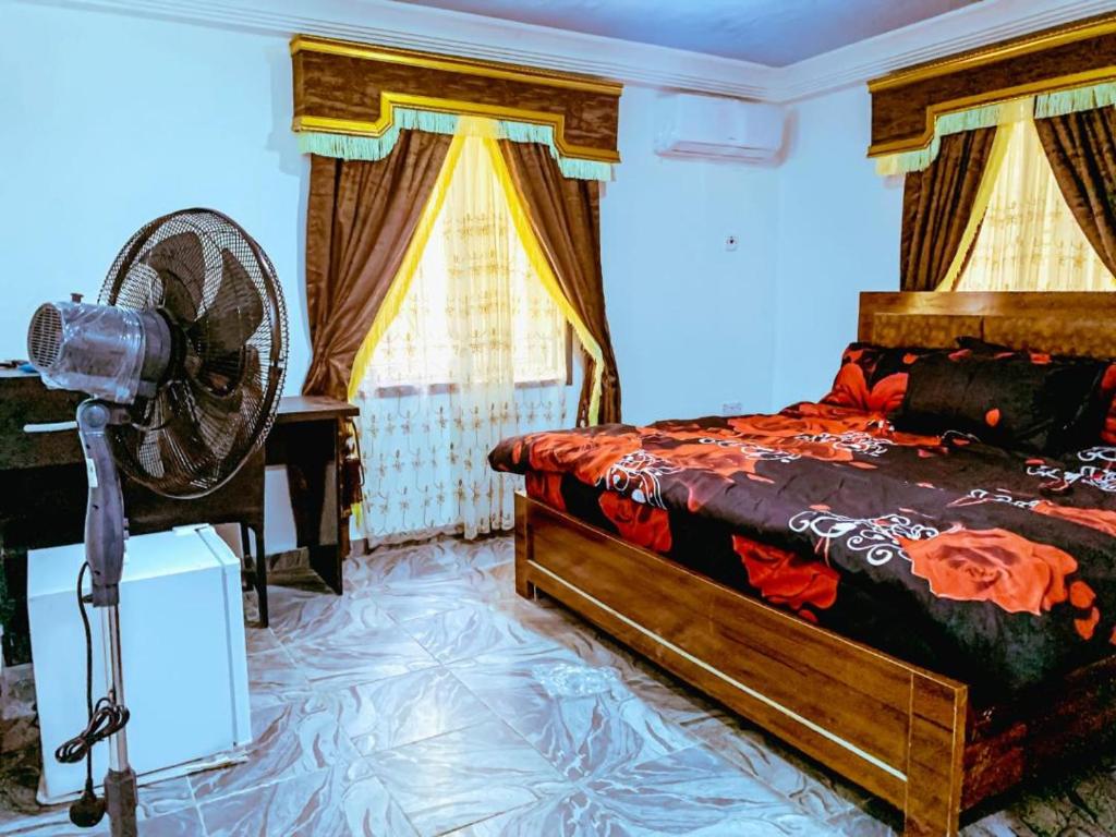 1 dormitorio con 1 cama y ventilador en una habitación en Select Elegant 3 Rooms 3 sized king-bed @ Abuja FCT en Abuja