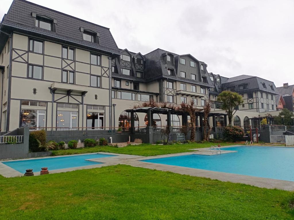 una casa grande con piscina frente a ella en Hotel Enjoy Pucon, en Pucón