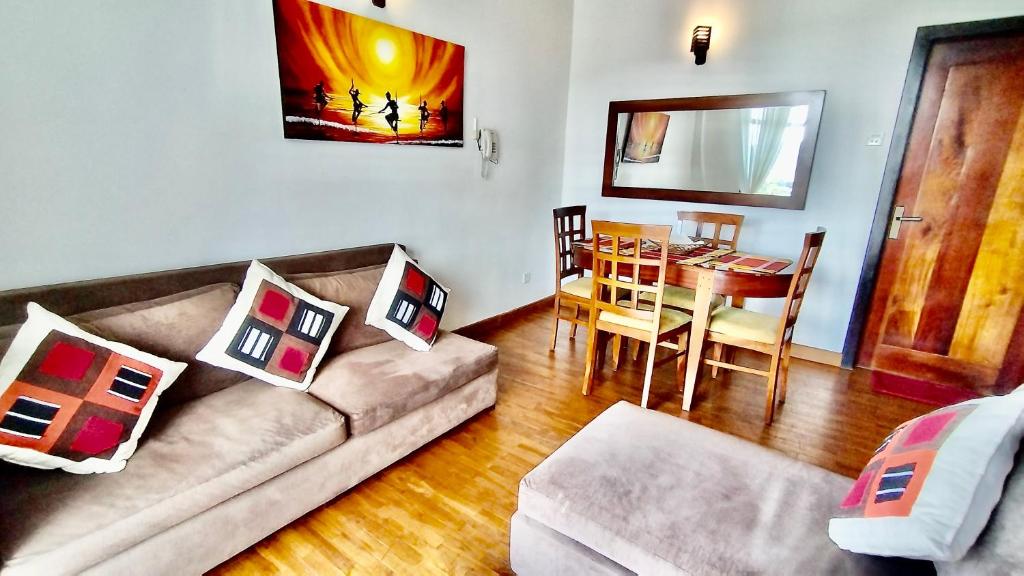 een woonkamer met een bank en een tafel bij Skylight Apartment in Nuwara Eliya