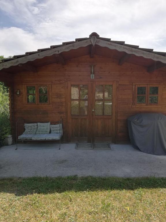 une cabane en rondins avec un banc devant elle dans l'établissement petit chalet dans verger et village Historique, à Molesmes