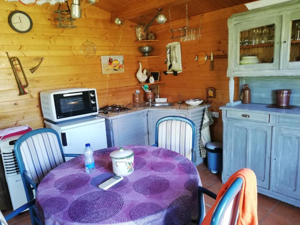 eine Küche mit einem Tisch und einem lila Tischtuch in der Unterkunft petit chalet dans verger et village Historique 