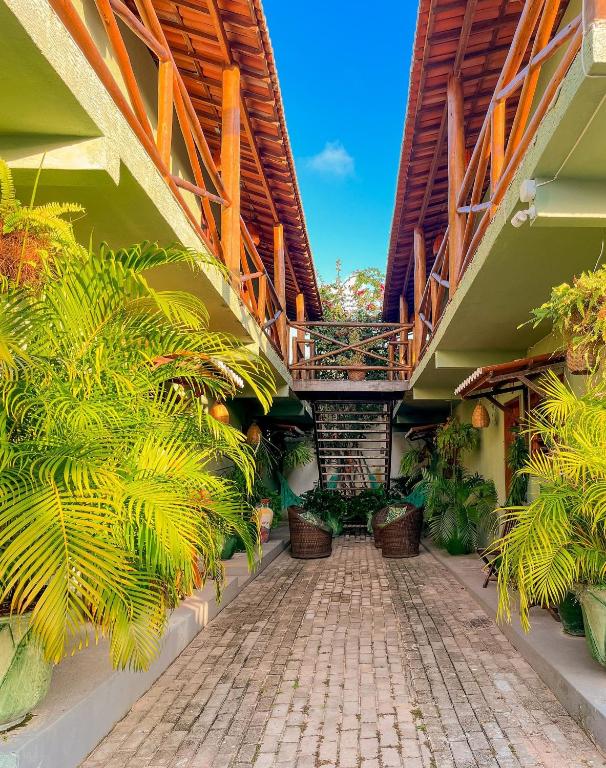 a courtyard of a building with potted plants at Kadosh Pipa Hospedagem in Pipa