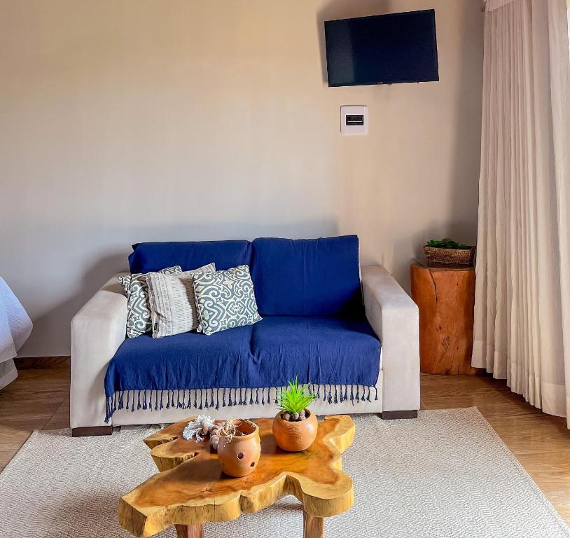 uma sala de estar com um sofá azul e uma mesa em Kadoshi Pipa Boutique Hospedagem em Pipa