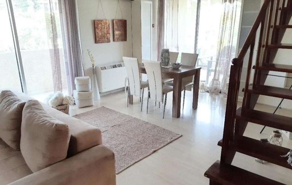 een woonkamer met een bank en een tafel met stoelen bij 6 pax Glyfada 2floor apartment in Athene