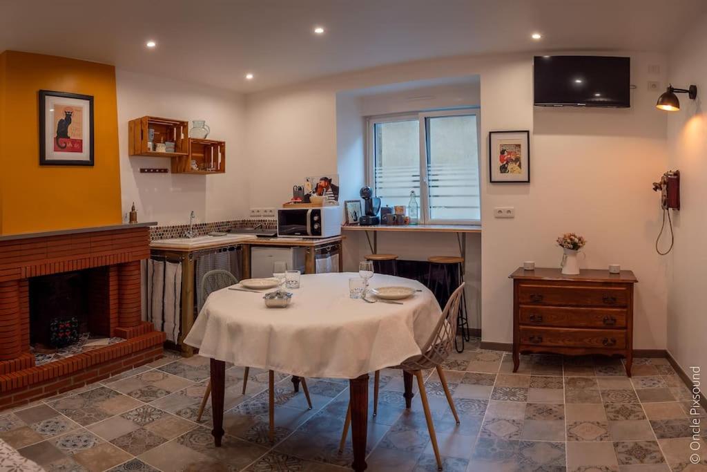 uma cozinha com uma mesa com uma toalha de mesa em Studio Le chat’Oh! em Combourg