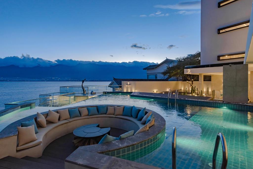 una piscina con vistas al agua por la noche en Dali Oriental Seaview Hotel -Dali Erhai, en Dali