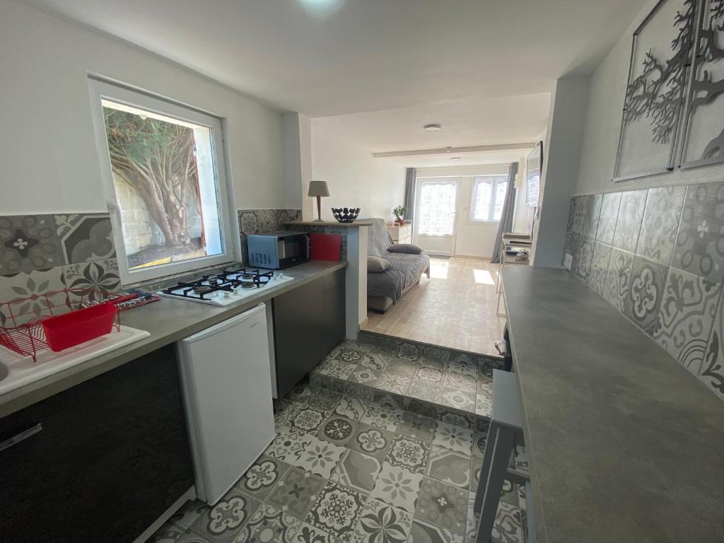 uma cozinha com uma bancada e um fogão forno superior em La Foulnerie Studio avec cour autonome 61270 Rai proche 61300 l'Aigle 
