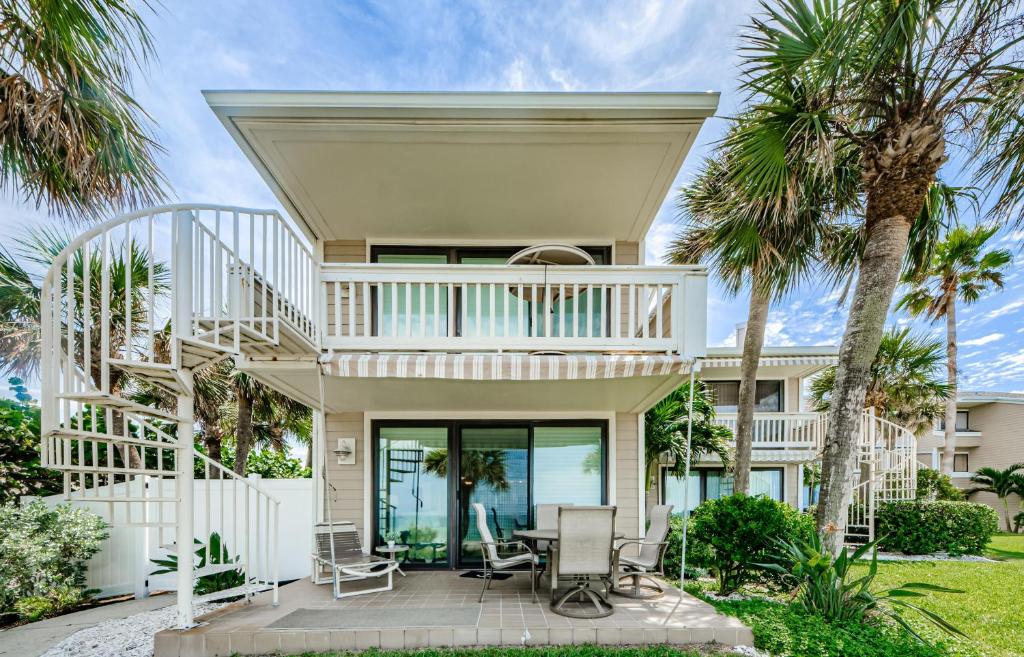 una casa con una escalera de caracol que conduce a un patio con palmeras en Sonrisa 1 en Clearwater Beach