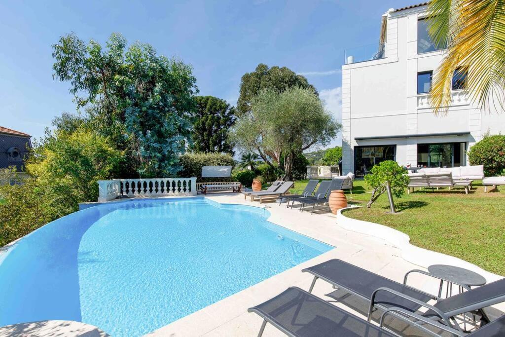 - une piscine avec des chaises et une maison dans l'établissement Belvedere - Villa Luxe Montfleury, à Cannes