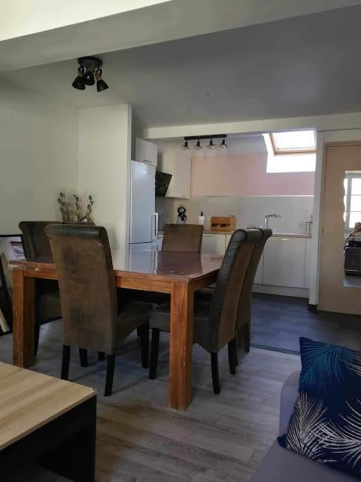 - une table à manger et des chaises dans la cuisine dans l'établissement appartement duplex, à Beaune-la-Rolande