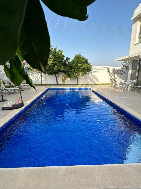 una piscina con acqua blu in un cortile di Villa Victoria a Larnaka