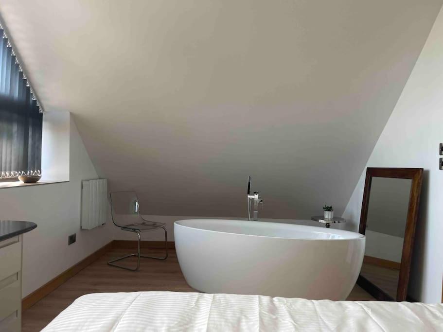a white bath tub in a room with a bed at The pump house hot tub retreat outskirts of leeds in Leeds
