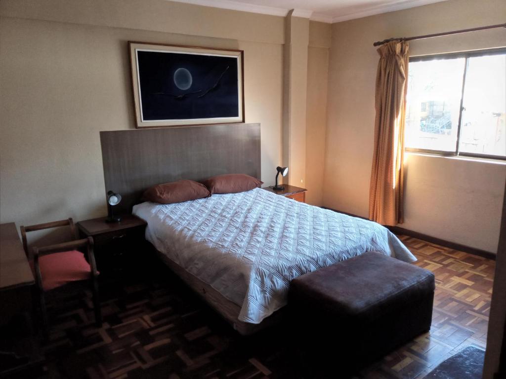 Un dormitorio con una cama grande y una ventana en APARTAMENTO, CENTRO DE LA CUIDAD, en Cochabamba