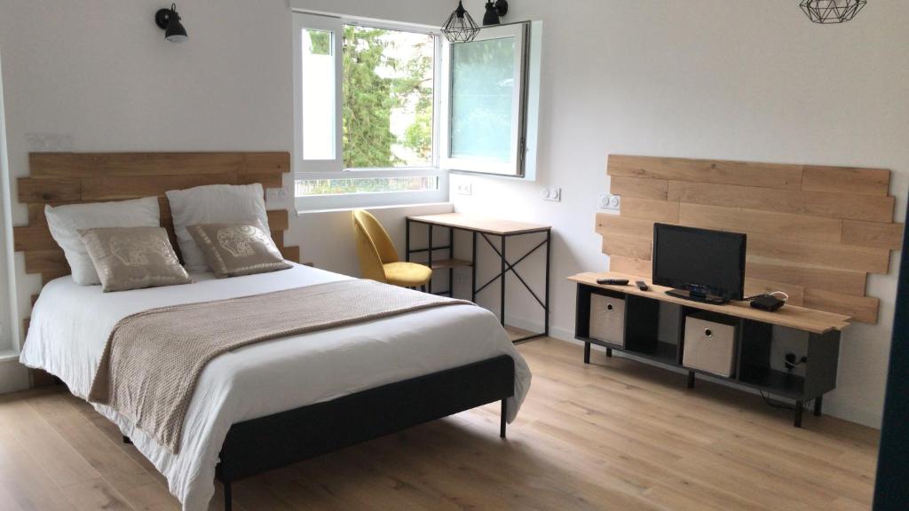 1 dormitorio con 1 cama grande y TV en Studio 35m2 en Fougères