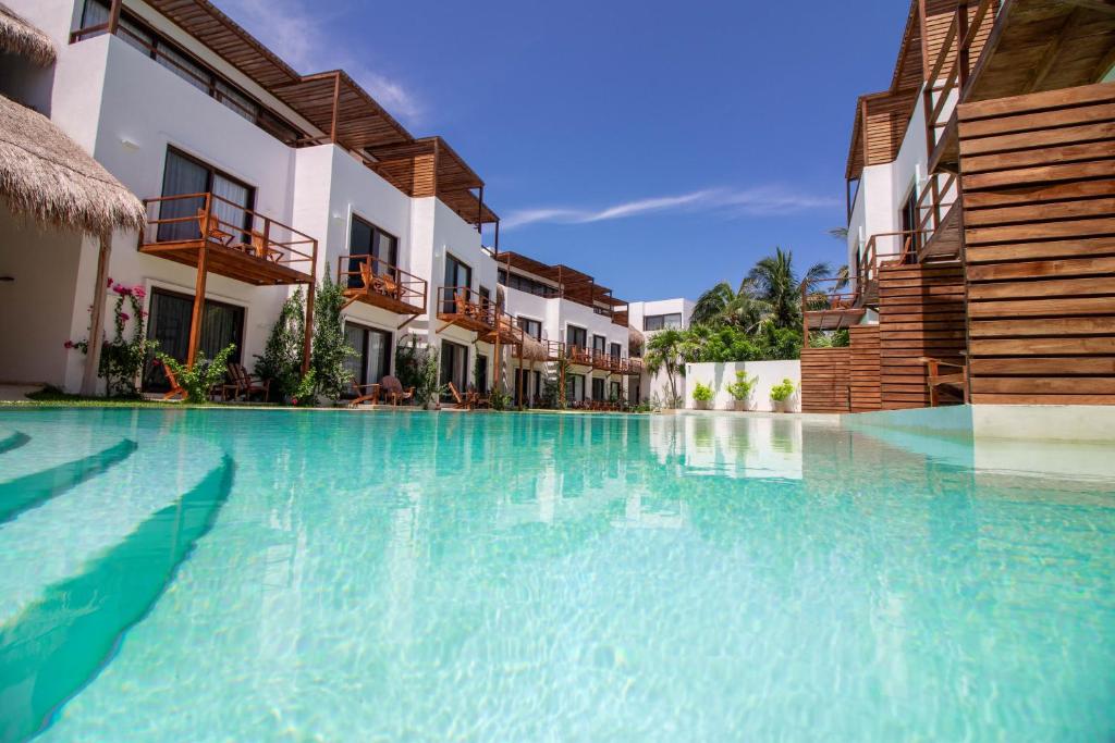 una piscina en un complejo con agua azul en My Blue Hotel Holbox en Holbox Island