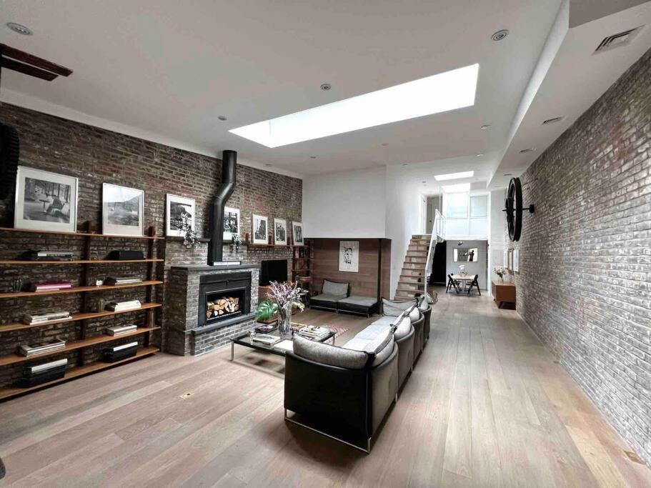 uma sala de estar com um sofá e uma parede de tijolos em Superb Duplex Penthouse in FIDI em Nova York