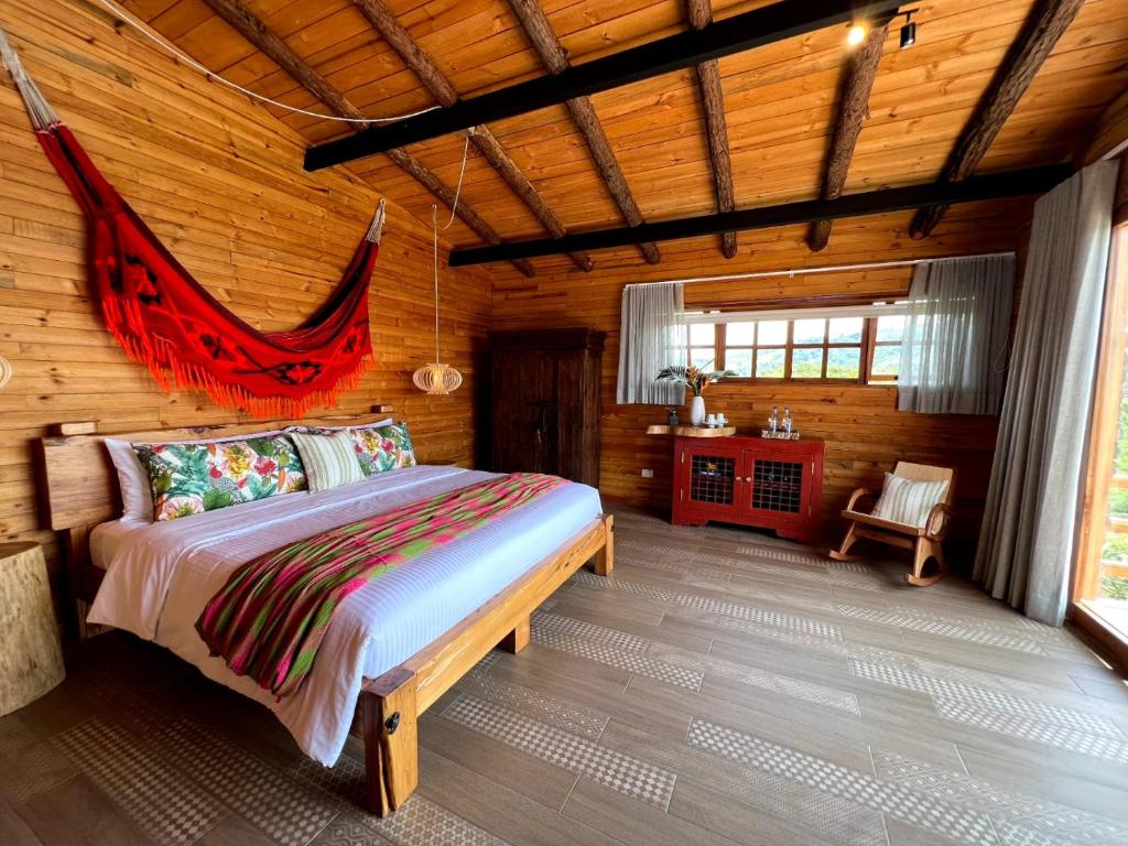a bedroom with a bed in a log cabin at LA PERLA FINCA HOTEl- Cabaña Esmeralda in Gigante