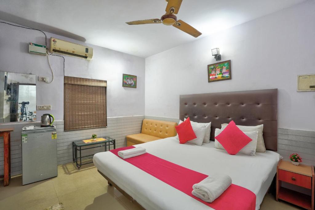 1 dormitorio con 1 cama grande con almohadas rojas en Dolphin service apptment en Calangute