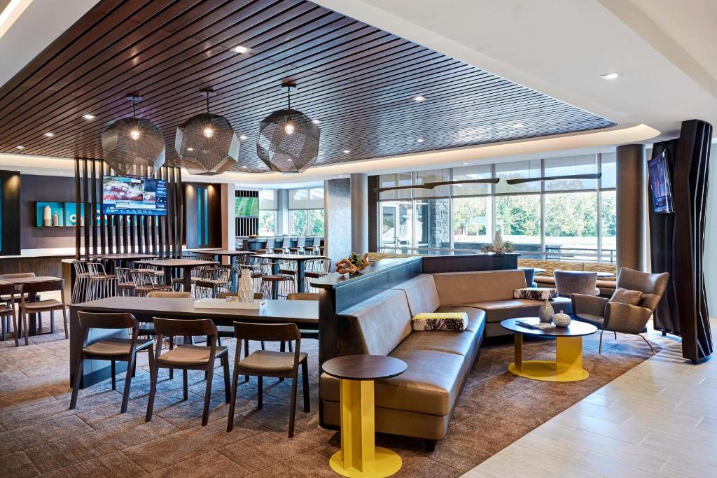a restaurant with a couch and tables and chairs at SpringHill Suites by Marriott Canfield in Canfield