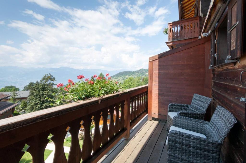 two chairs on a balcony with a view of the mountains at Alpe Fleurie Hôtel & Restaurant in Villars-sur-Ollon