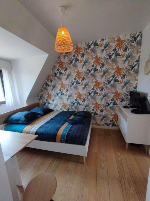 une chambre avec un lit, une table et une chaise dans l'établissement Le ptit nid de Louviers TV/Fibre, à Louviers