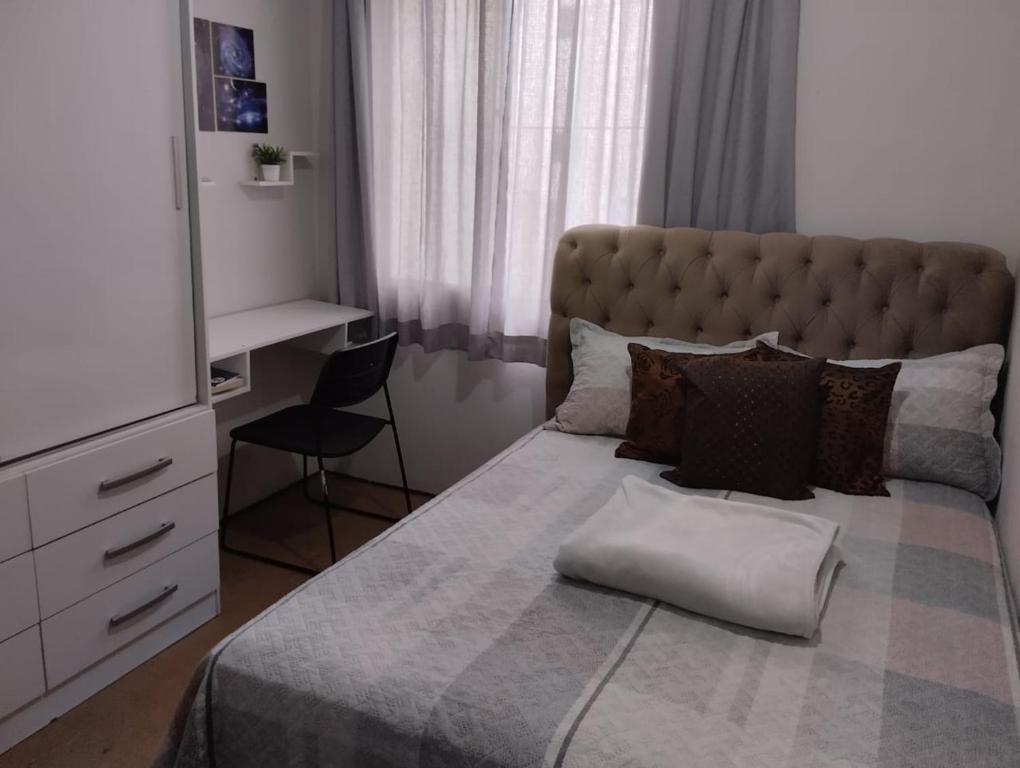 1 dormitorio con 1 cama grande y escritorio en Andres Home casa H, en Governador Valadares
