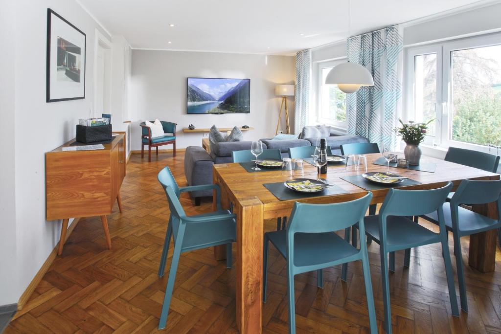 a dining room and living room with a table and chairs at Haus Welzel in Dresden