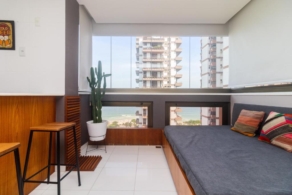 ein Schlafzimmer mit einem Bett und einem großen Fenster in der Unterkunft Flat Ocean View II in Rio de Janeiro