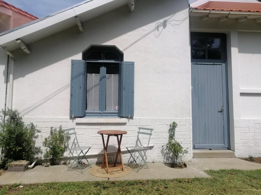 een tafel en stoelen voor een huis bij Kaiola in Saint-Georges-de-Didonne
