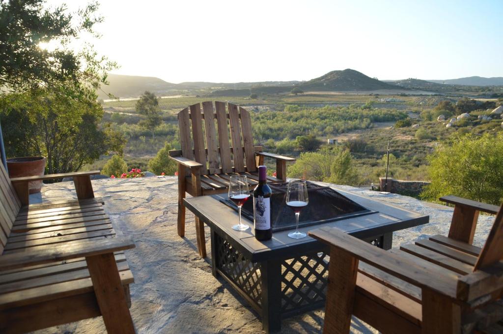 Finca Jorsan في إنسينادا: طاولة مع كرسيين وزجاجة من النبيذ