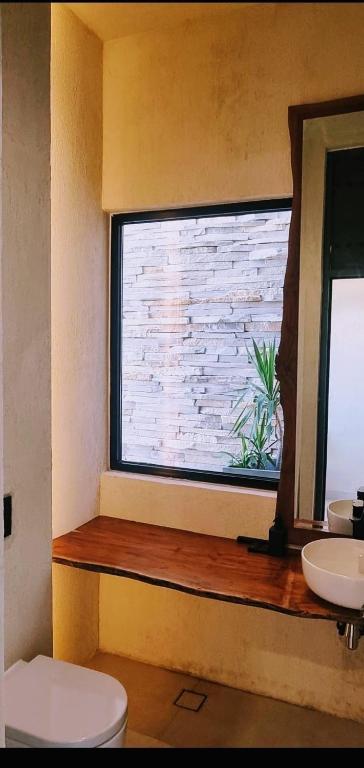 a bathroom with a window with a toilet and a sink at The Gate in Sur