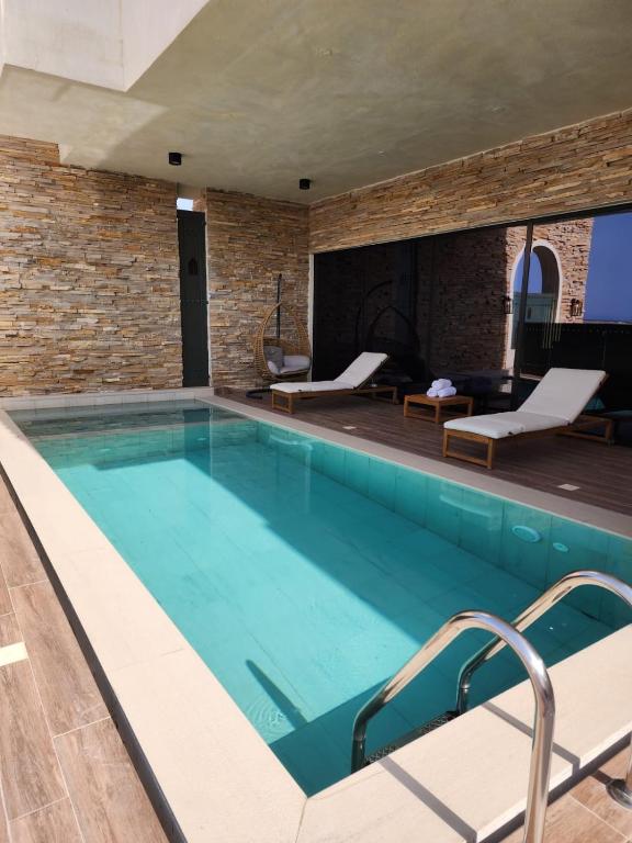 a large swimming pool with a brick wall at The Gate in Sur