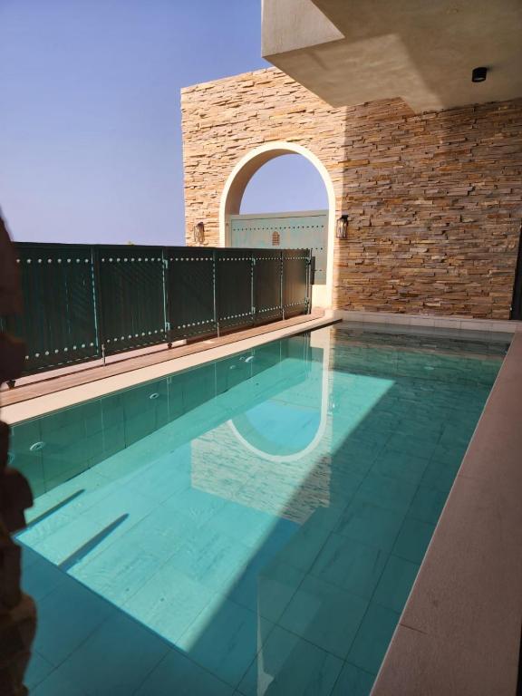 a swimming pool in a building with a brick wall at The Gate in Sur