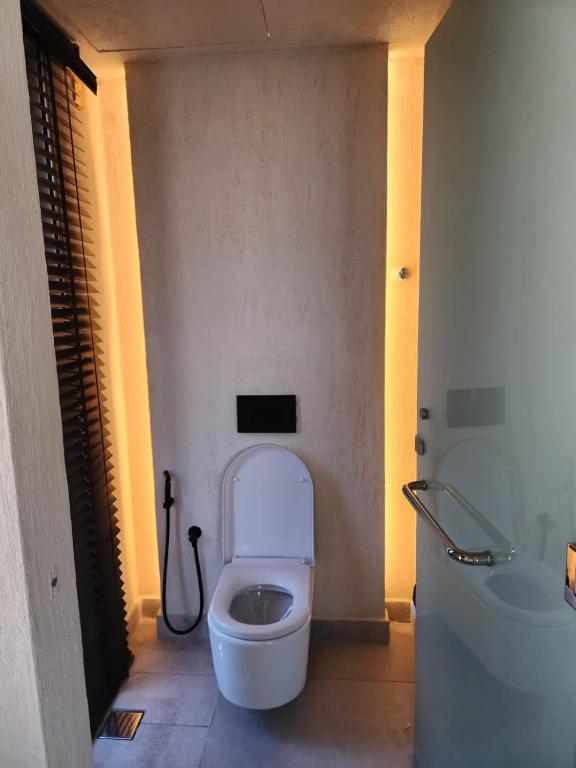 a bathroom with a white toilet in a room at The Gate in Sur
