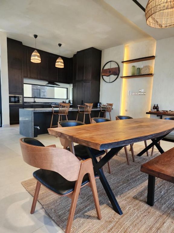 a dining room with a wooden table and chairs at The Gate in Sur