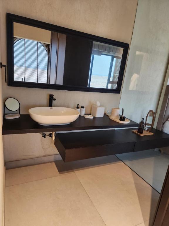 a bathroom with a sink and a large mirror at The Gate in Sur