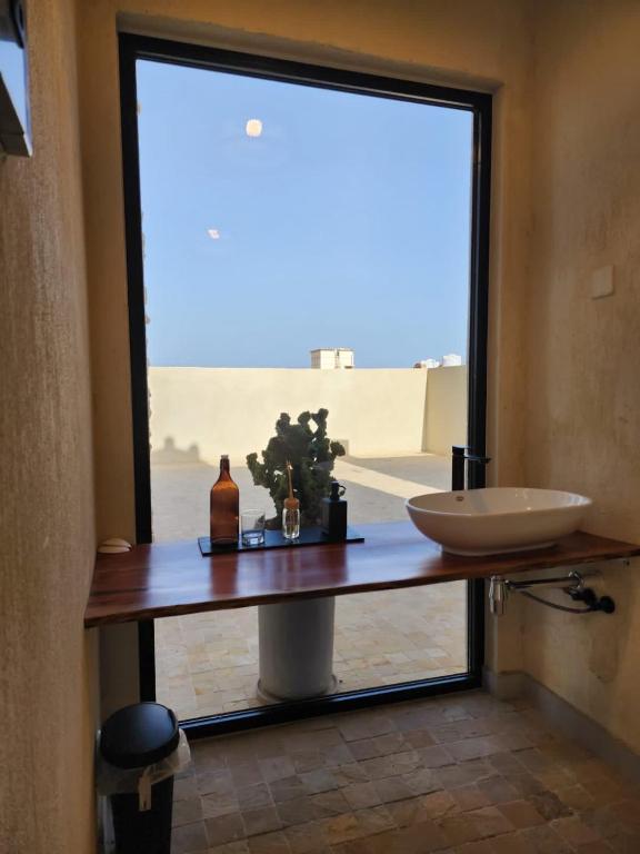 a bathroom with a counter with a sink and a window at The Gate in Sur