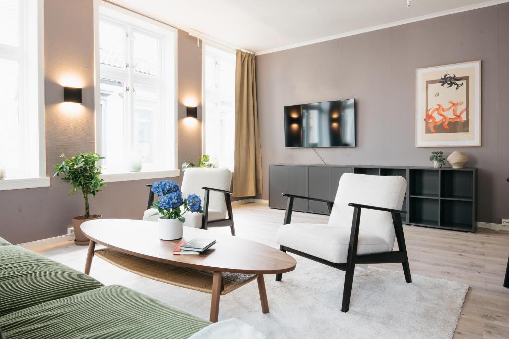 un soggiorno con divano, tavolo e sedie di S54 - Private Rooms in the City Center a Bergen