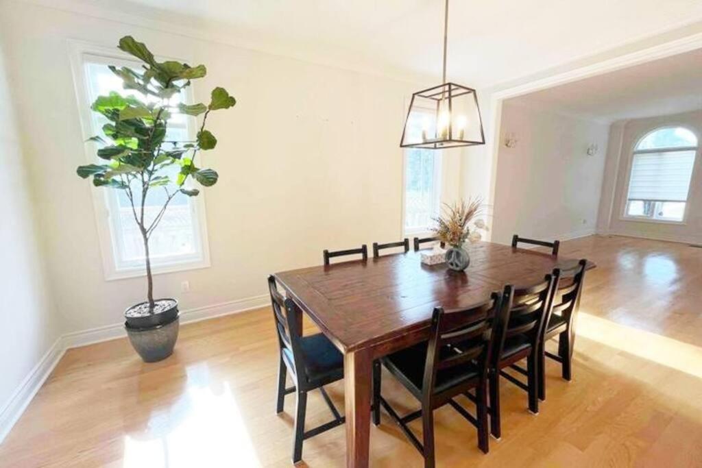 a dining room with a wooden table and a potted plant at New and Cozy House 5min to Yonge and Finch in Toronto