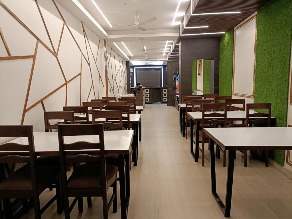 una fila di tavoli e sedie in una sala da pranzo di Hotel Satyam a Jaigaon