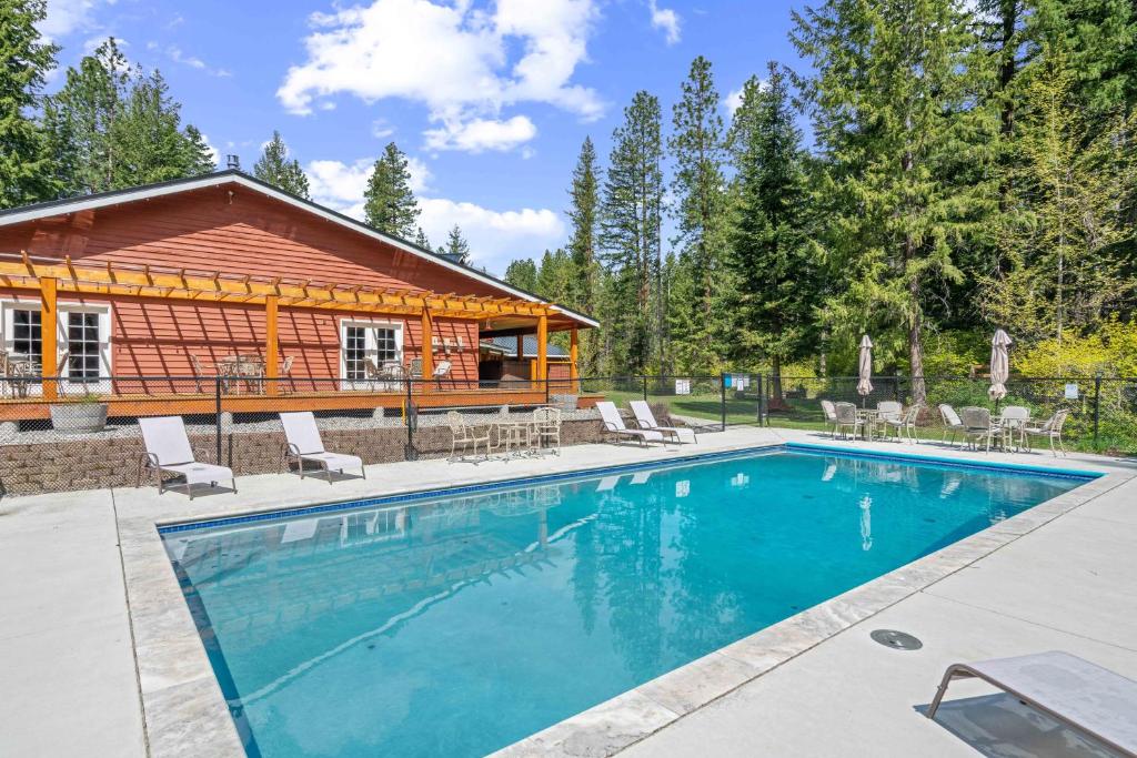 a swimming pool in front of a log cabin at River Road Lodge by NW Comfy Cabins in Leavenworth