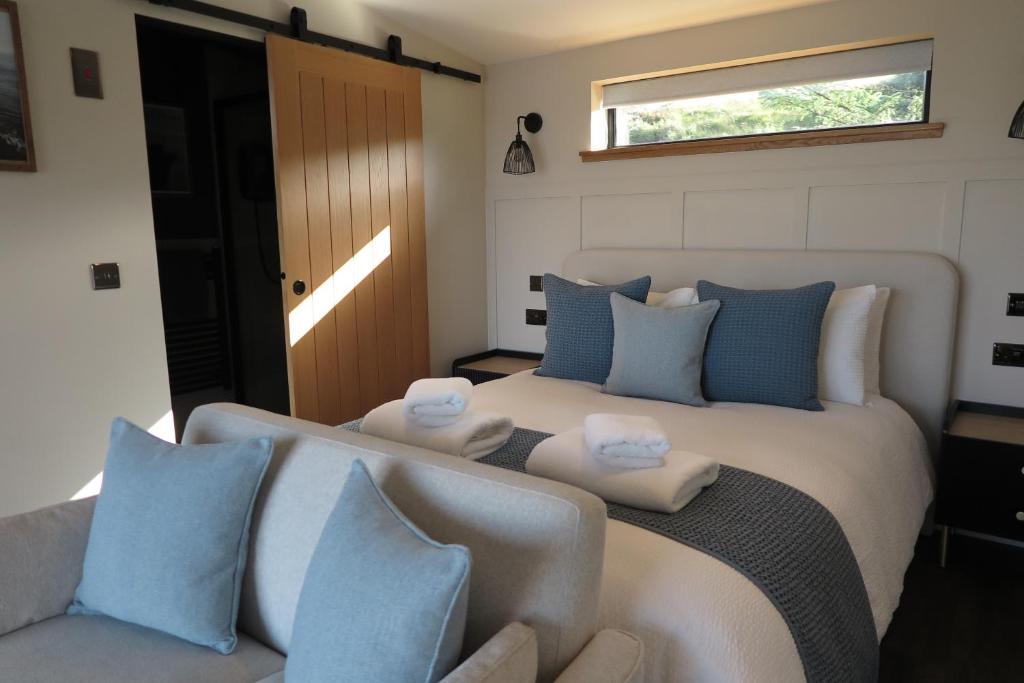 1 dormitorio con 1 cama grande con almohadas azules y blancas en Angusfield Cabins, en Sconser