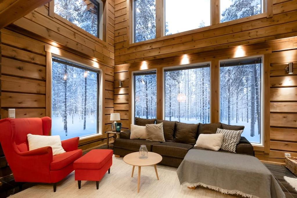 sala de estar con sofá, sillas y ventanas en Charming log house - Lumous B - Pyhätunturi - Finland en Pyhätunturi