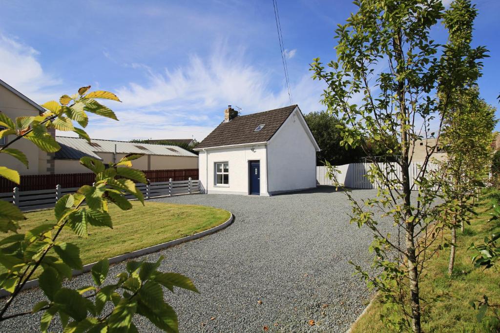 a white house with a driveway at The Wee House in Muff