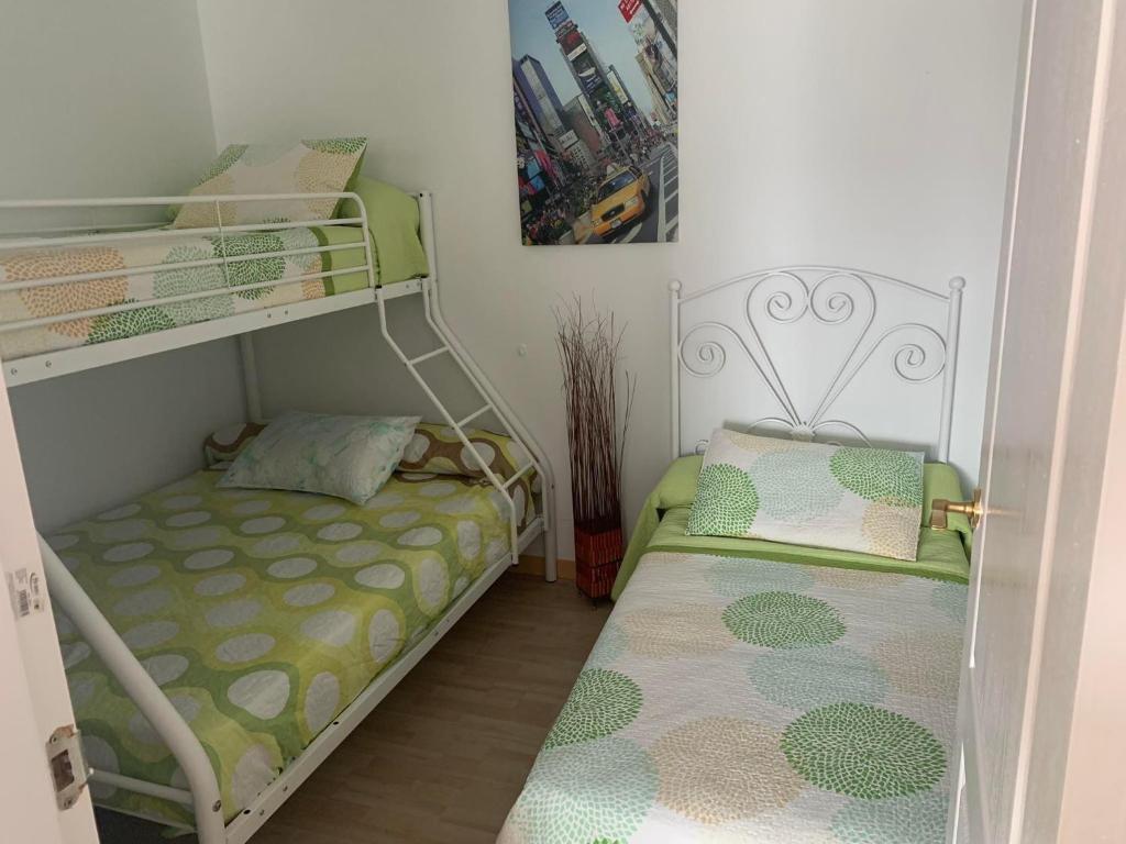 ein kleines Zimmer mit zwei Etagenbetten in der Unterkunft Apartamento in Sanlúcar de Barrameda