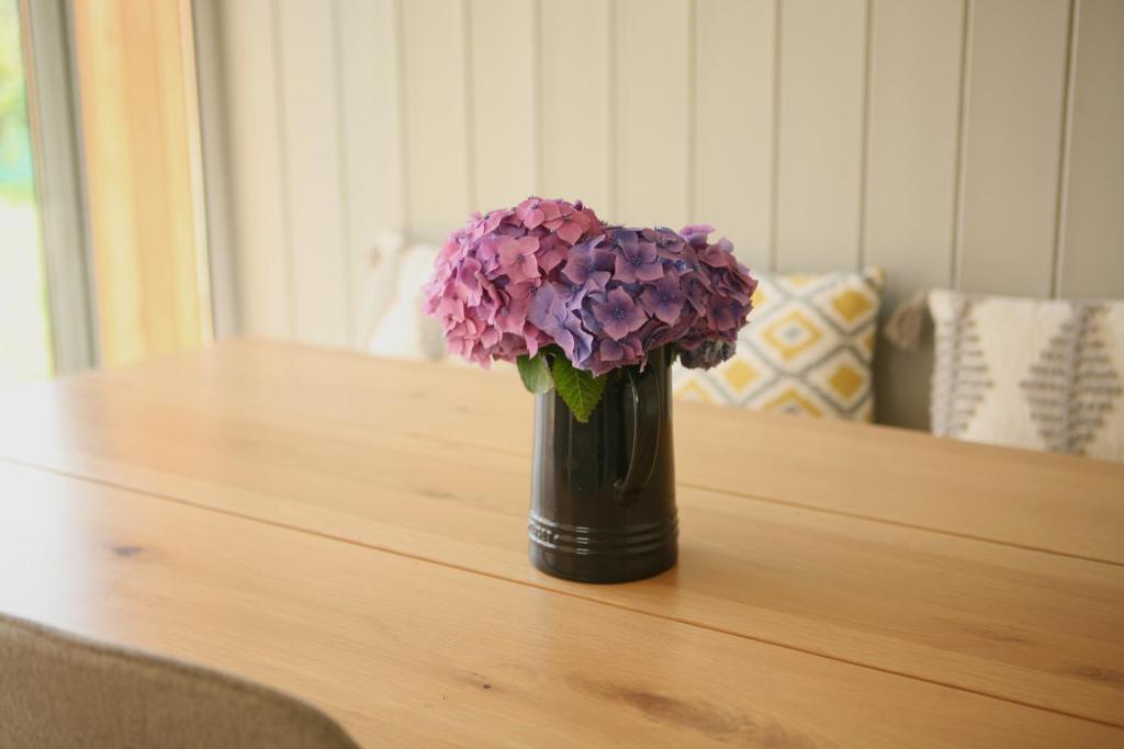 a vase filled with purple flowers sitting on a table at Ocean Breeze in Cork
