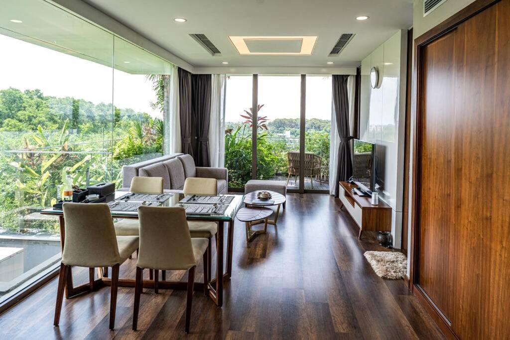 sala de estar con mesa, sillas y TV en 1BR, 1 Sofa bed Luxurious 5-stars Flamingo Resort., en Phúc Yên