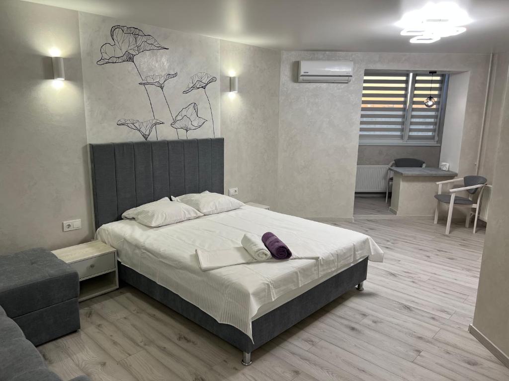 sypialnia z dużym łóżkiem z fioletową poduszką w obiekcie бул. Шевченка 352, квартира-студія w Czerkasach