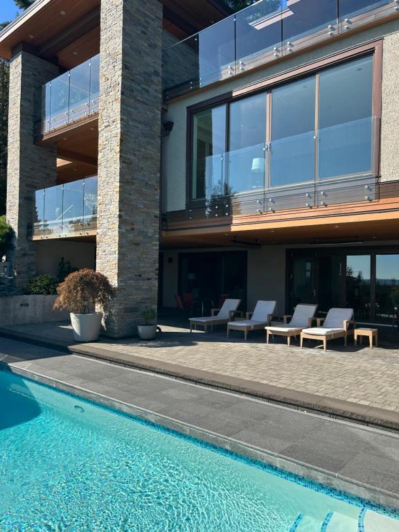 Luxury accomodation in West Vancouver في فانكوفر الغربية: منزل به مسبح بجانب مبنى