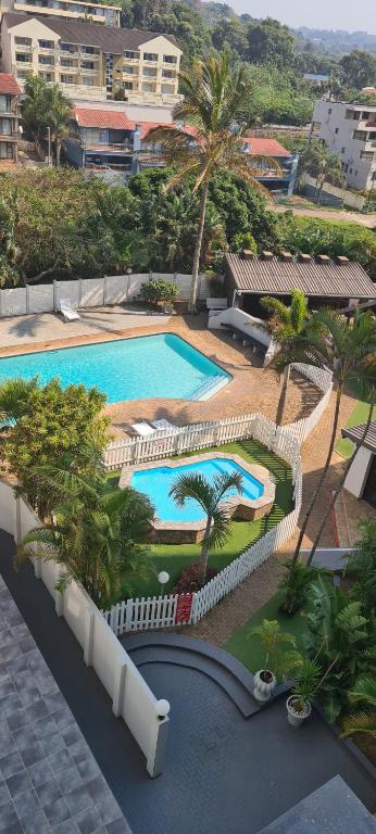 an overhead view of a pool with palm trees and buildings at Santana holiday resort 803 in Margate